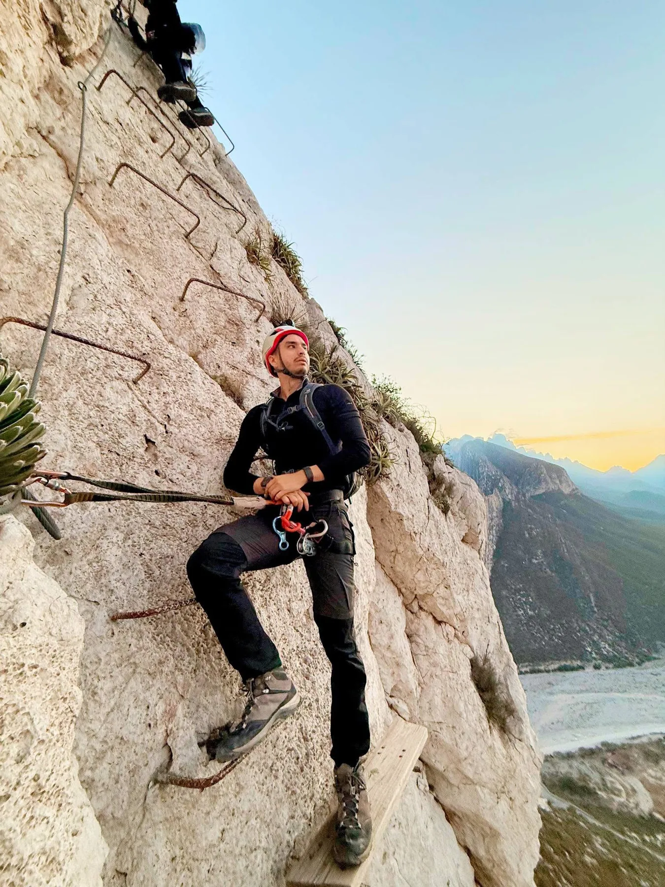 Aventurero asegurado en una vía ferrata sobre una pared de roca